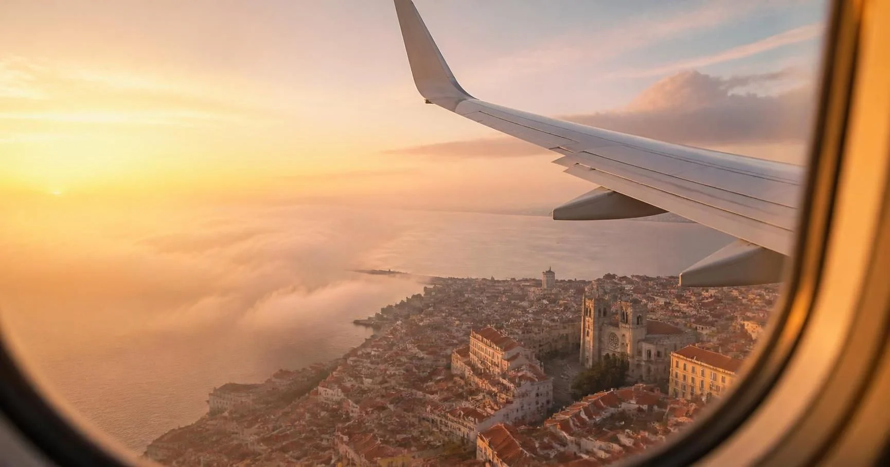Airplane window view of a European city at sunrise on a flight to Europe